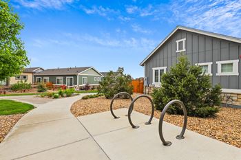 A park with a swing set in front of a house